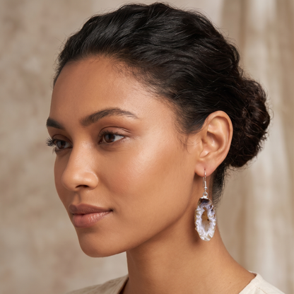 Close-up side profile of a model wearing an organic silver-plated hook agate geode earring, highlighting the natural un-edged stone crust and sparkling crystal center.