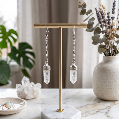 Premium plated twisted-chain raw Clear Quartz point earrings displayed on a minimalist jewelry stand.